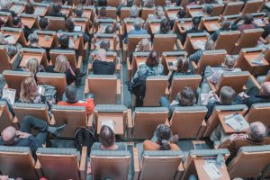 Photo of conference attendees sitting in an auditorium.